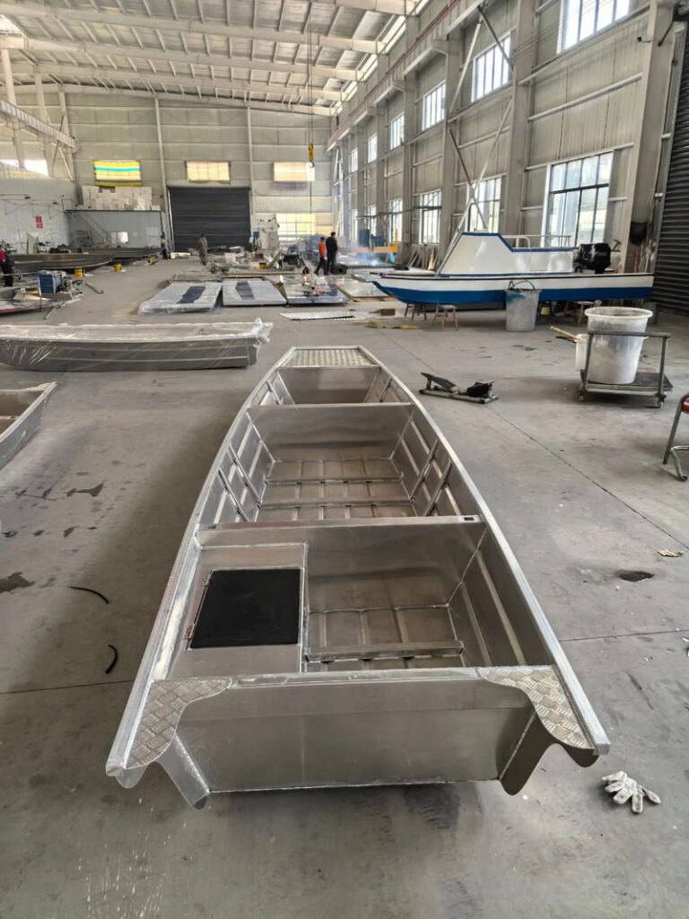 Aluminum flat bottom boat under construction inside a boatbuilding workshop
